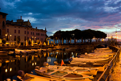 Desenzano Del Garda marina with fishing boats in early morning, just before dawn.